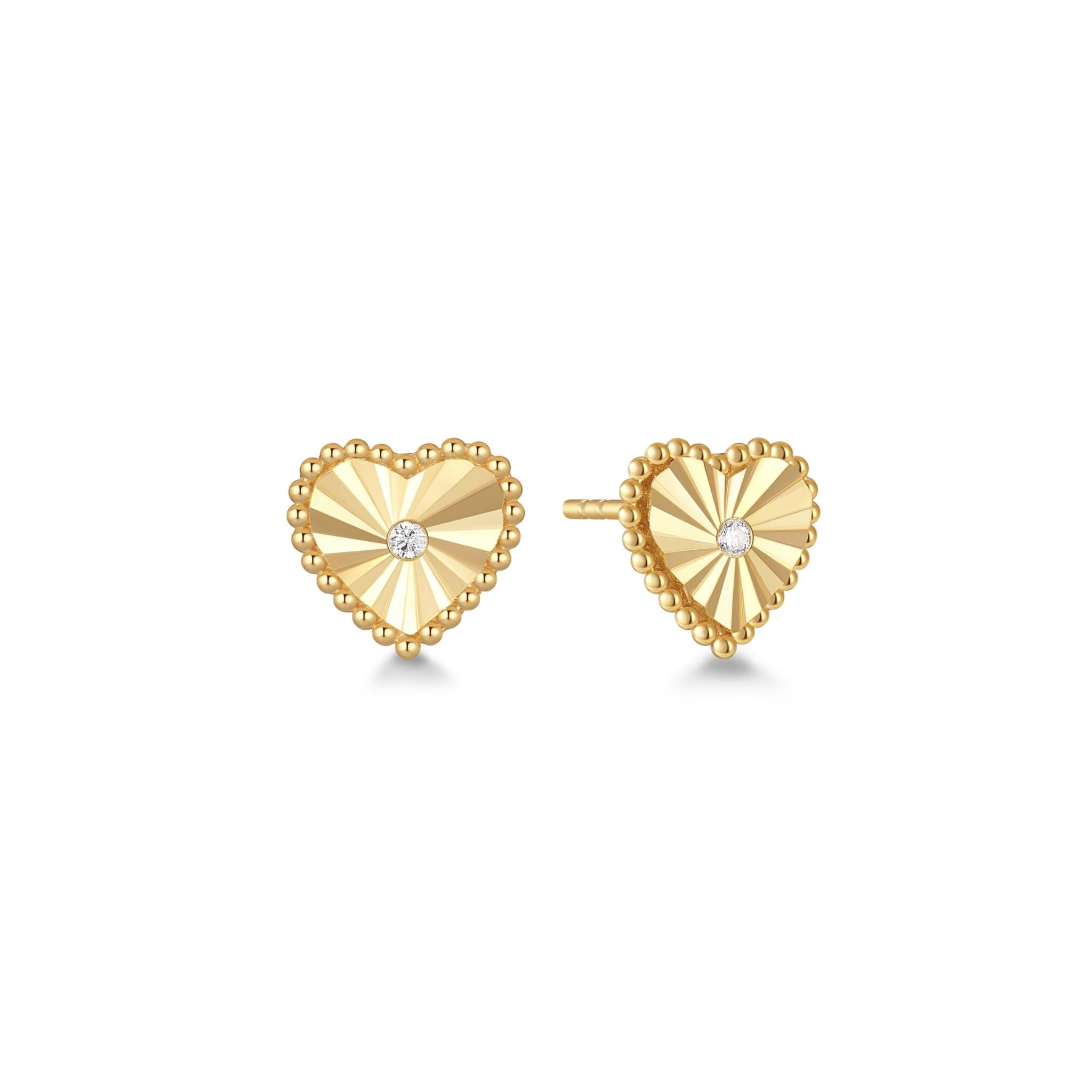 Gold heart-shaped earrings with a cubic zirconia center on a white background

