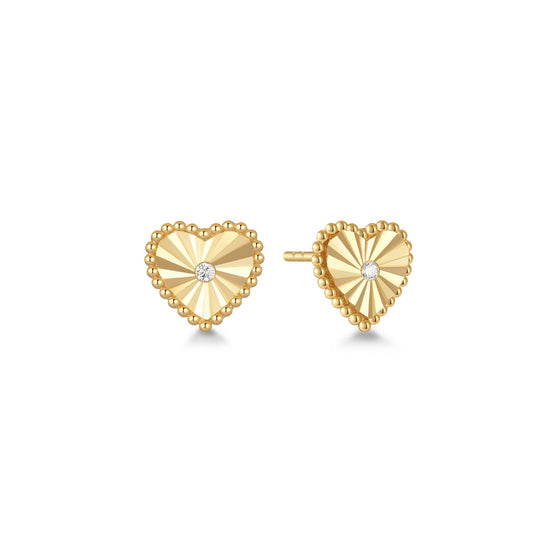 Gold heart-shaped earrings with a cubic zirconia center on a white background

