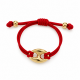 A red braided cord bracelet with polished gold-tone metal beads and a central oval gold charm