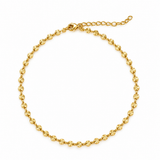 A delicate gold chain necklace featuring small, textured circleshaped links.