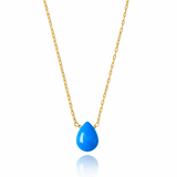Gold necklace with a blue teardrop pendant on a white background