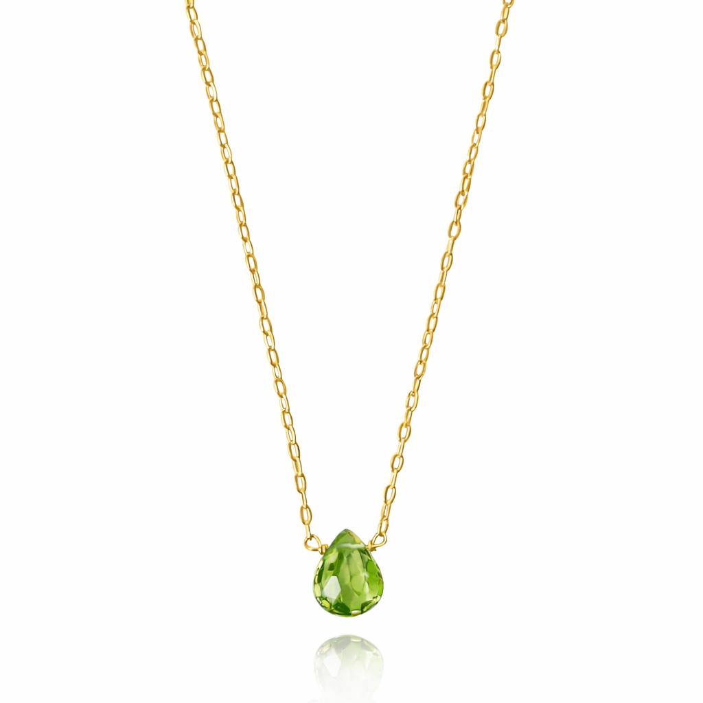 Gold necklace with a green teardrop pendant on a white background