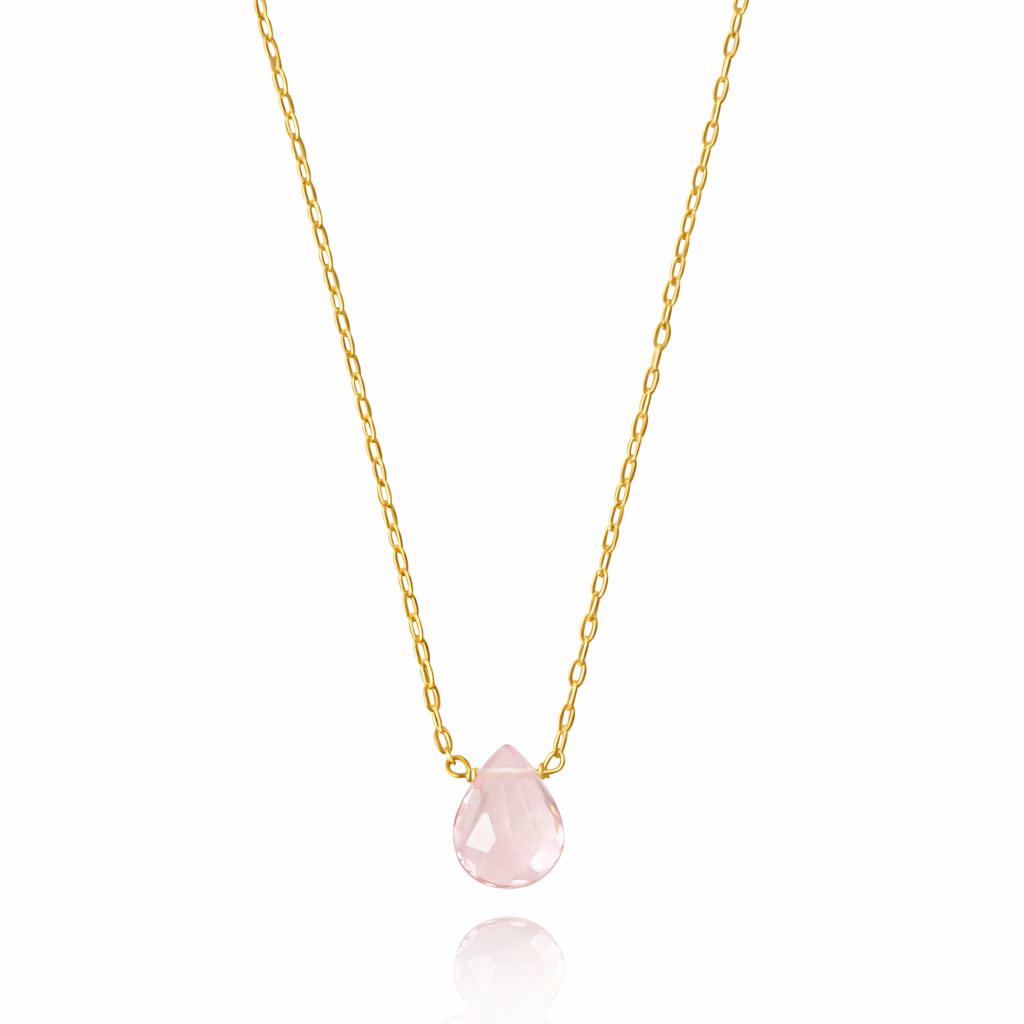 Gold necklace with a pink teardrop pendant on a white background