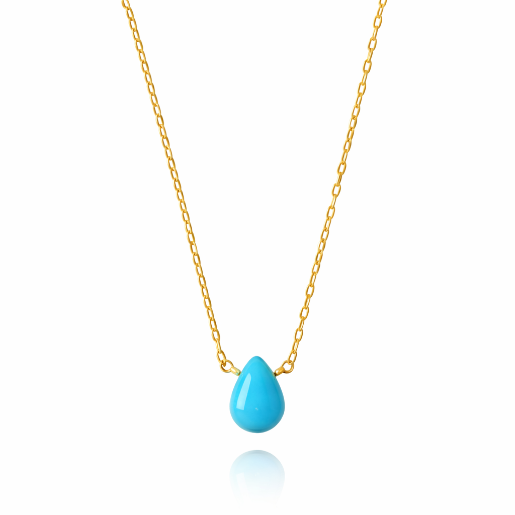 Turquoise teardrop pendant on a gold chain against a white background
