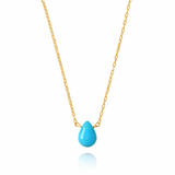 Turquoise teardrop pendant on a gold chain against a white background